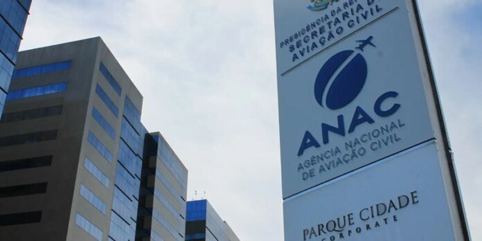 Sign for ANAC (Agência Nacional de Aviação Civil) with blue logo beside tall office buildings, in Parque Cidade Corporate area.