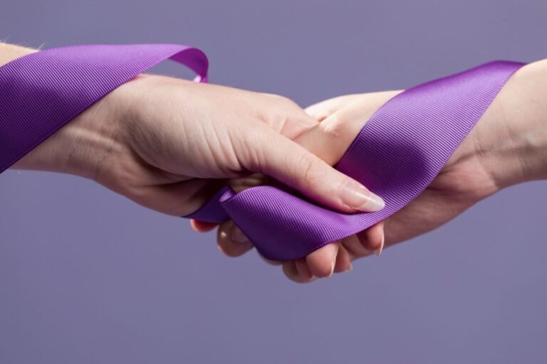 Two hands clasp a purple ribbon that loops around them, symbolizing connection or solidarity.