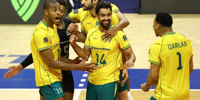 Brazilian men's volleyball players in yellow uniforms celebrate together on the court during a match.