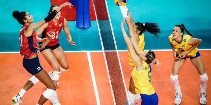 Volleyball action at the net: USA players in red and Brazil players in yellow leap to contest a spike on an orange court.