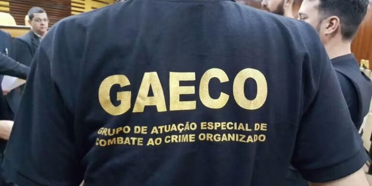 Back view of a dark jacket with large gold 'GAECO' lettering and the Portuguese caption for an anti-organized crime unit.