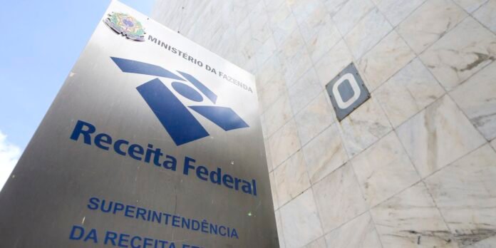 Metal sign for Receita Federal with logo, Ministe9rio da Fazenda, placed against a marble exterior wall outside a building, Brazil (informative)