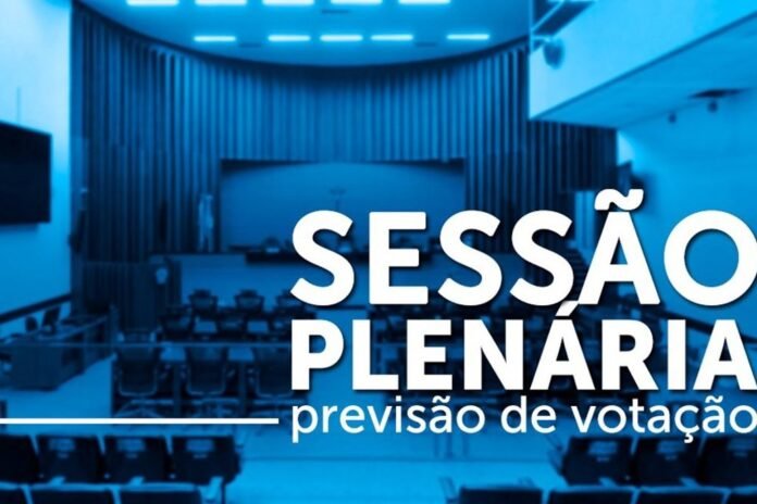 Auditorium with rows of seats under blue lighting and large white Portuguese text reading 'Sessão Plenária previsão de votação'.