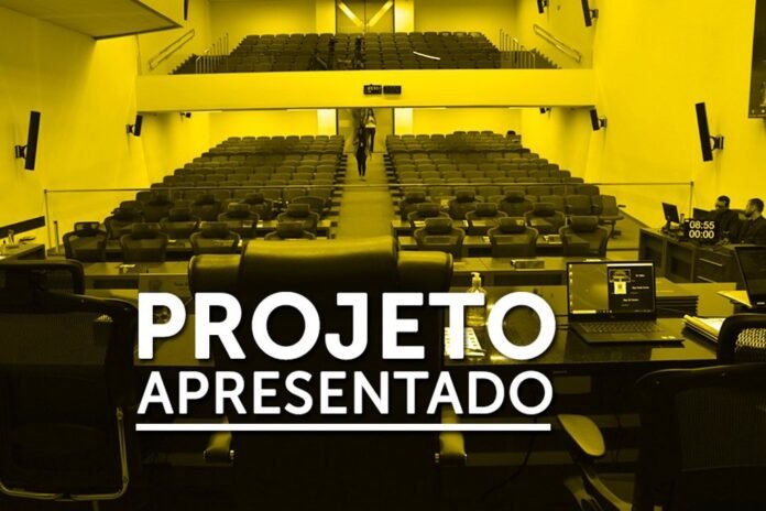 Empty auditorium with rows of seats and a front desk; bold overlay text reads 'PROJETO APRESENTADO' indicating a project presentation.