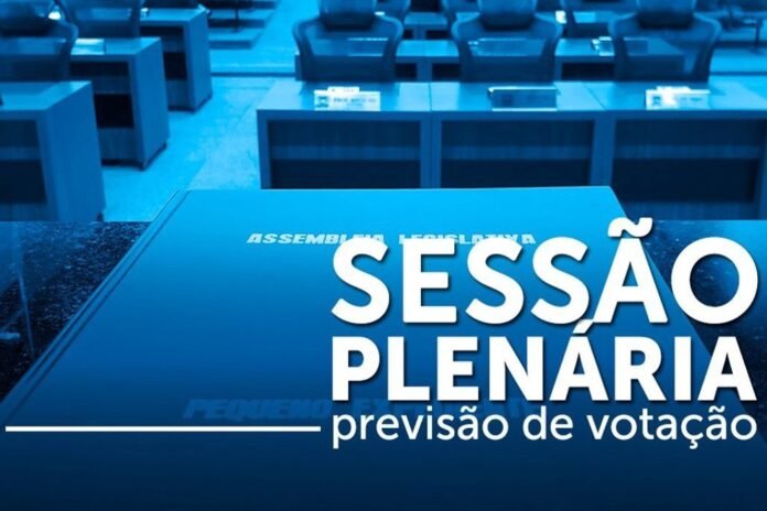 Blue-tinted conference room with empty seats and a desk displaying 'Sessão Plenária — previsão de votação', indicating a plenary session and voting forecast.
