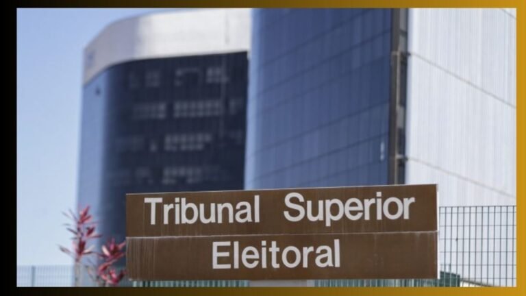 Brown sign with white text reading "Tribunal Superior Eleitoral" in front of modern blue buildings.