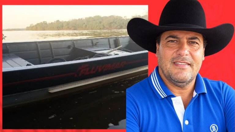 Man wearing a black cowboy hat and blue polo shirt, with a boat on a calm lake to his left against a red backdrop.