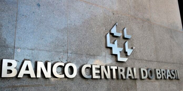 Banco Central do Brasil sign in metallic letters on a stone wall, with a geometric logo above the text