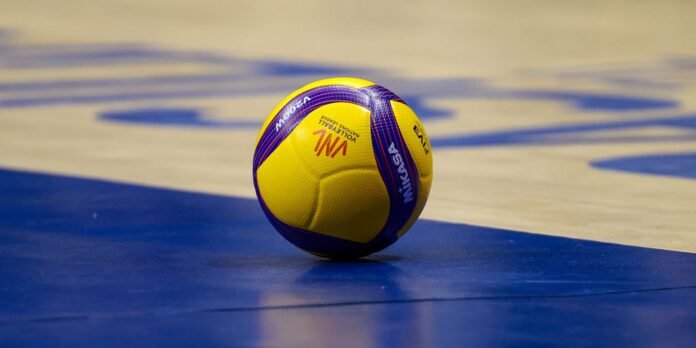 Yellow and purple volleyball on a blue indoor court.
