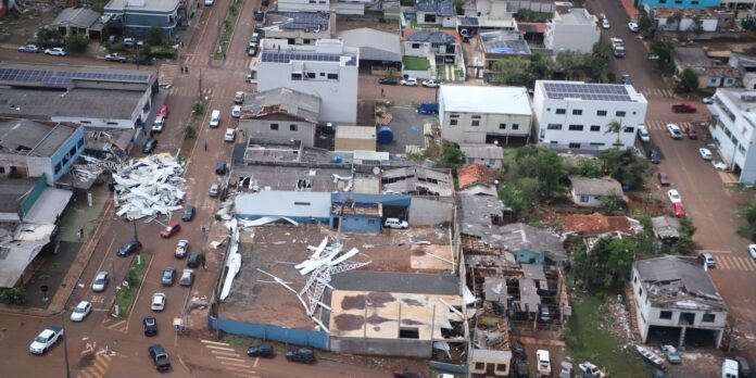Aerial view of a damaged urban area showing collapsed buildings, scattered debris, and cars on the street after a disasterrail
