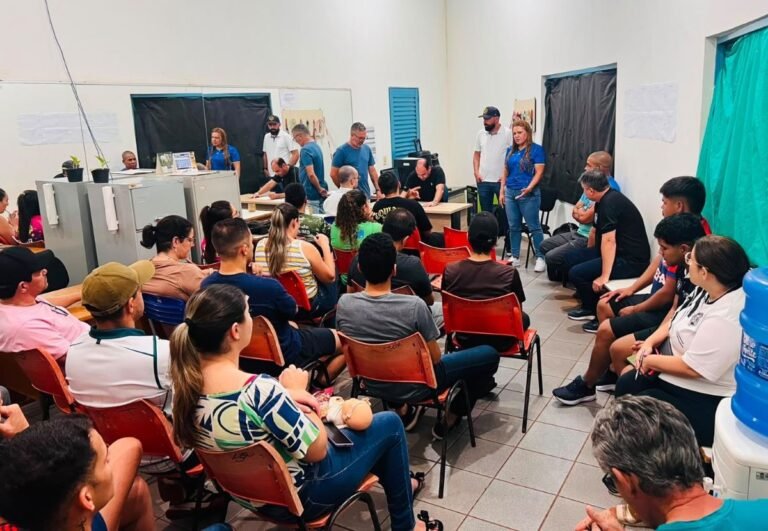 Community meeting in a room with a panel at the front and attendees seated in rows facing them.