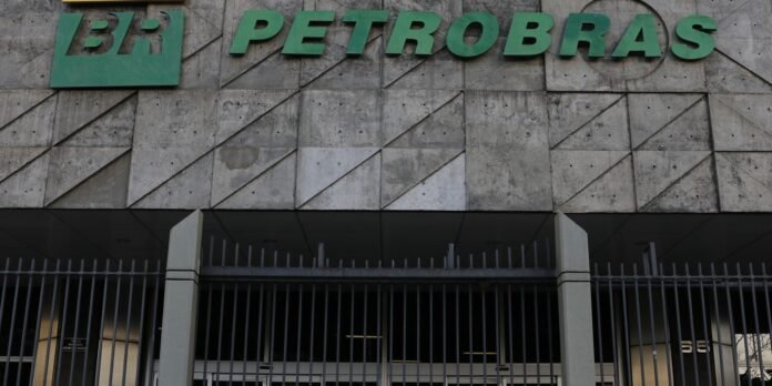 Petrobras building facade with a large green logo and letters above a gated entrance.