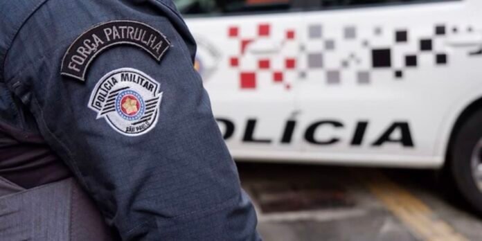 Polícia Militar patch on a dark uniform sleeve with a patrol badge, car with 'POLICIA' lettering in the background